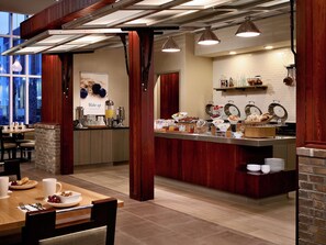 Zona de desayuno con barra libre, que incluye diversas opciones de comida y una estación de café.