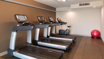 A gym with four treadmills, a red exercise ball, and a FlexDeck shock absorption system.