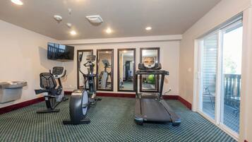 A fitness room with treadmills, elliptical machines, and a stationary bike.