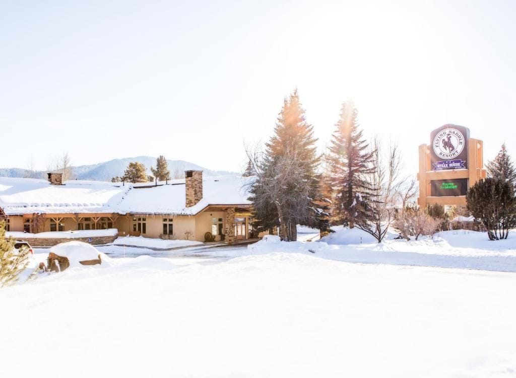 A snow-covered building with a sign indicating it's a ski resort.
