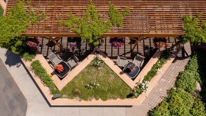 An outdoor seating area with a wooden pergola, tables, and chairs. - Flying Saddle Resort (Alpine)