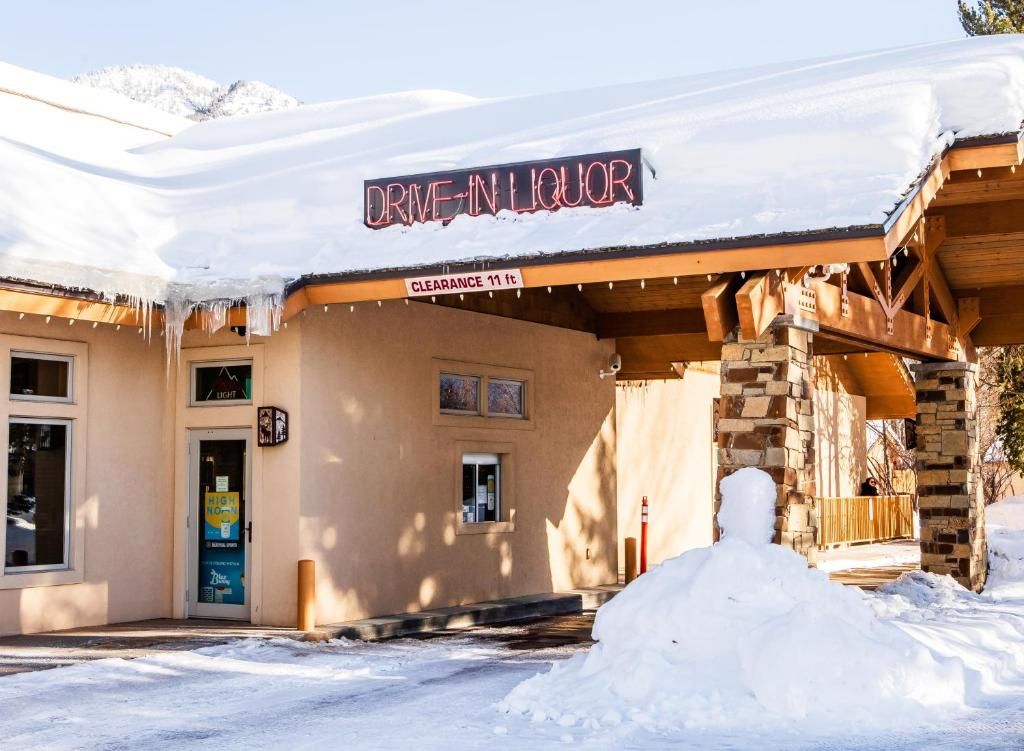 A building with a sign reading 'DRIVE-IN LIQUOR' and a clearance sign indicating 11 ft.