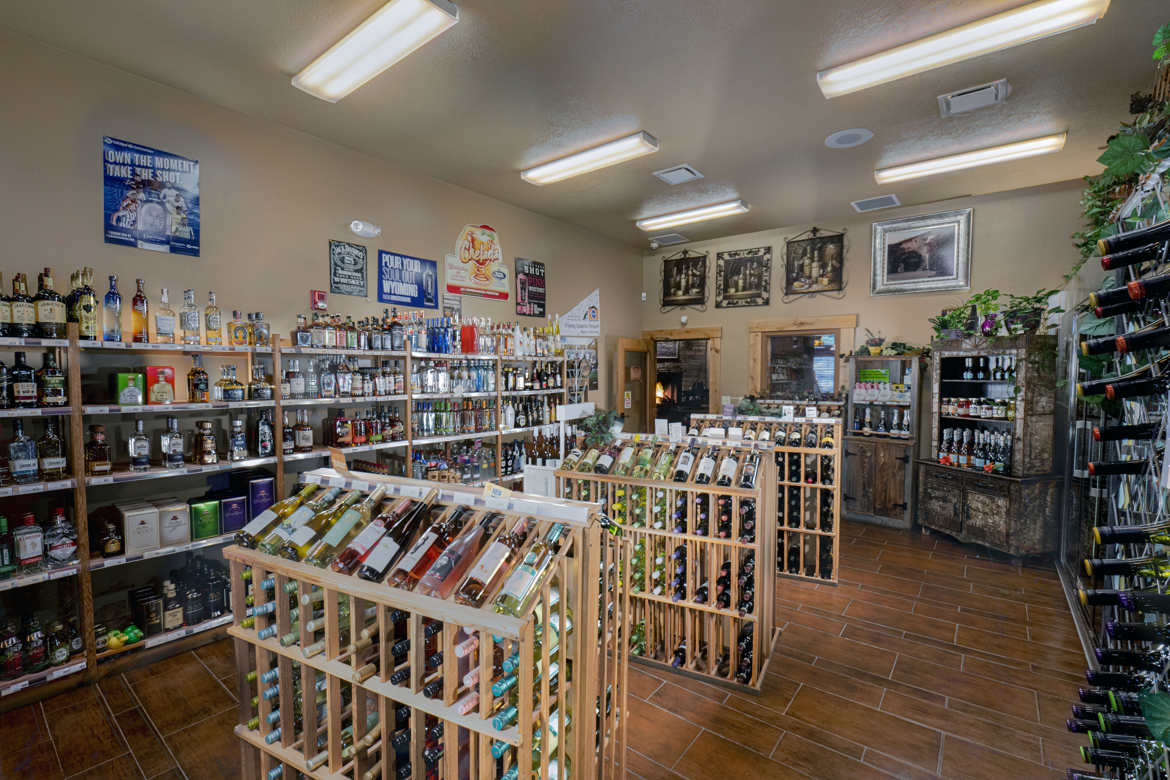 A well-lit liquor store with shelves of various bottles and wine racks.