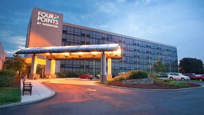 A modern hotel with a large glass facade, a covered entrance, and a landscaped driveway. - Four Points by Sheraton Philadelphia Northeast (Philadelphia)