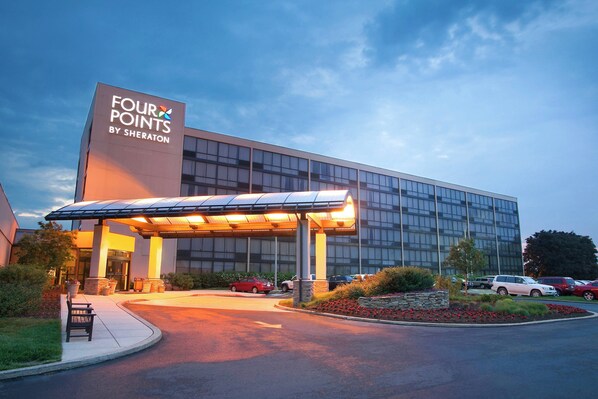 A modern hotel with a large glass facade, a covered entrance, and a landscaped driveway. - Four Points by Sheraton Philadelphia Northeast (Philadelphia)