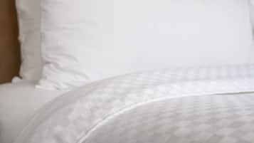 Uma cama com um edredom estampado e almofadas.