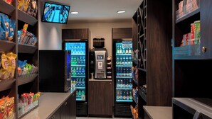 A self-service kiosk area with snack and drink dispensers, a television screen, and a vending machine. - Four Points by Sheraton Philadelphia Northeast (Philadelphia)