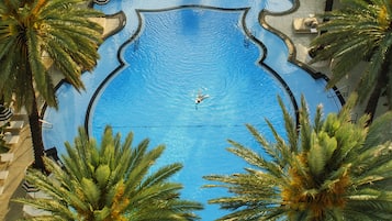 Una piscina al aire libre, sillones reclinables de piscina