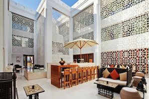 A spacious indoor area with a bar, seating, and a decorative wall. - Hilton Luxor Resort & Spa (Luxor)
