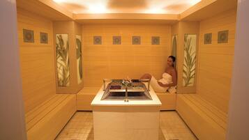 Ein Spa-Raum mit Holzverkleidung, einer Bank und einem kleinen Tisch mit Blumenarrangement.