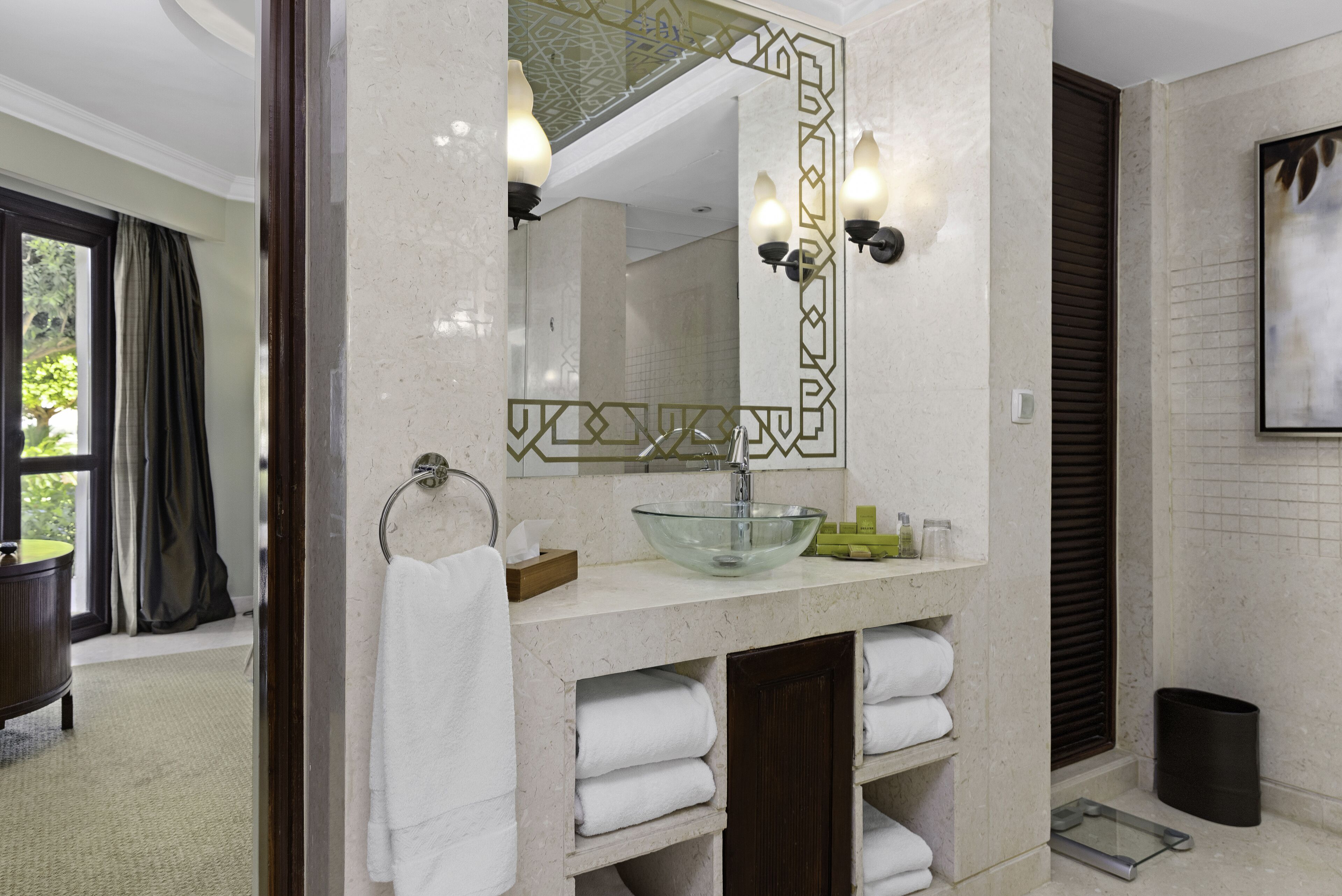 A modern bathroom with a glass bowl sink, a large mirror, and a towel rack.