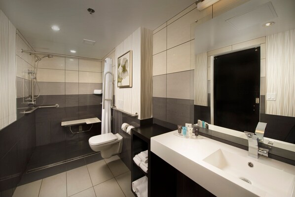 A modern bathroom with a shower, toilet, and sink.