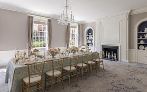 A formal dining room with a long table, chairs, a chandelier, and a fireplace. - The Carolina Inn, a Destination by Hyatt Hotel (Chapel Hill)