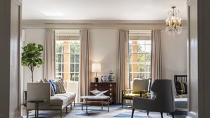 A spacious living room with a sofa, armchairs, a coffee table, and a chandelier. - The Carolina Inn, a Destination by Hyatt Hotel (Chapel Hill)