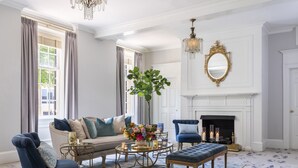 A well-lit living room with a sofa, armchairs, a coffee table, and a fireplace. - The Carolina Inn, a Destination by Hyatt Hotel (Chapel Hill)
