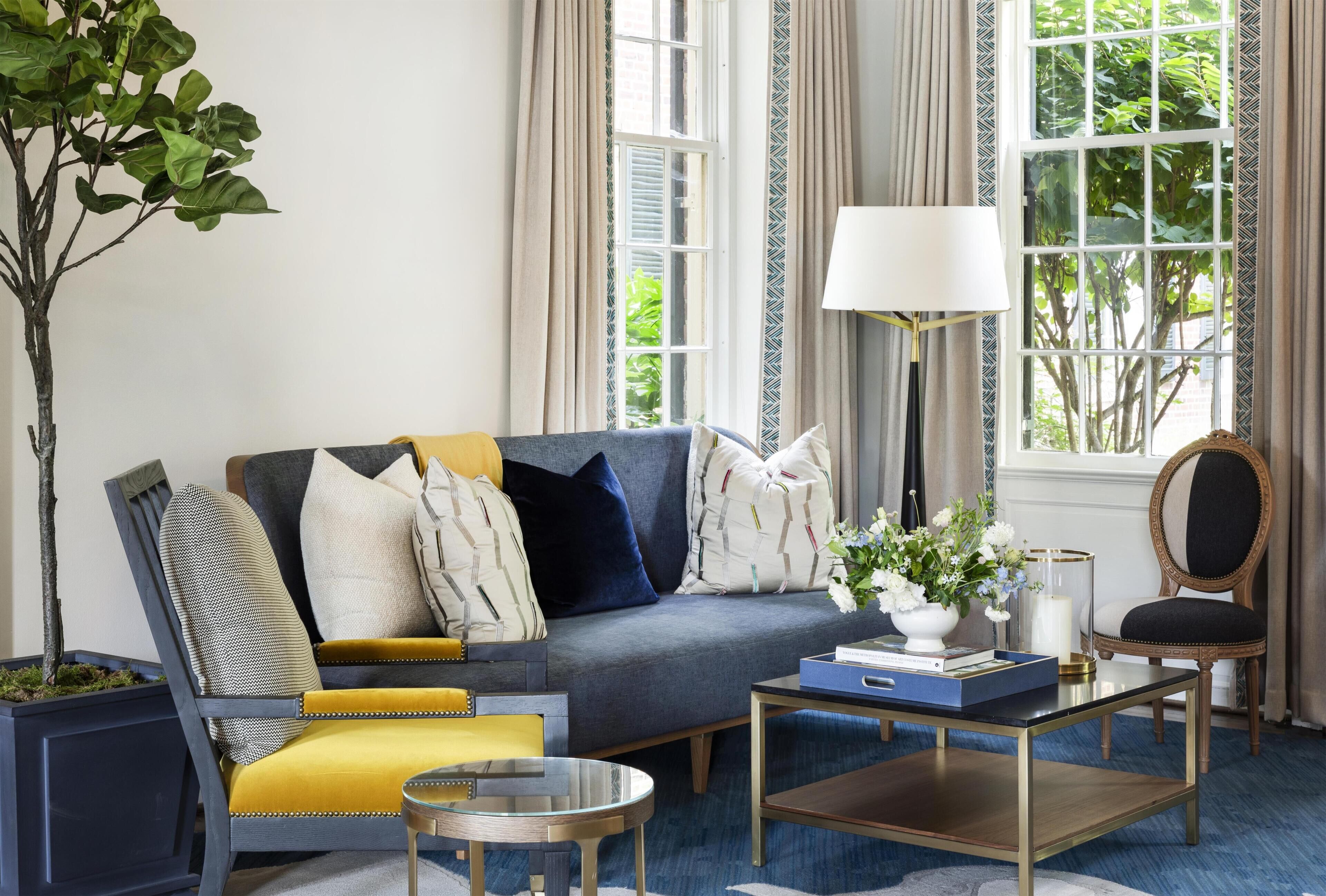 A living room with a sofa, armchairs, a coffee table, and a floor lamp.