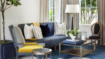 A living room with a sofa, armchairs, a coffee table, and a floor lamp.