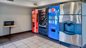Un espace de vente proposant des distributeurs automatiques de Pepsi et de Coca-Cola, un four à micro-ondes et un réfrigérateur de la marque Scotsman.