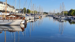 A marina with multiple boats docked along the water's edge, surrounded by buildings and trees. - Hotel ibis Vannes (Vannes)