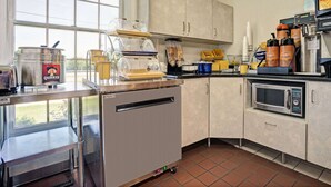 A kitchen with a coffee machine, a blender, and a microwave. - Travelodge by Wyndham Red Wing (Red Wing)