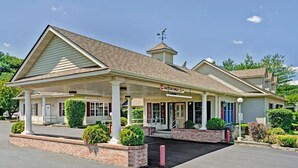 A two-story building with a covered front porch, a sign indicating 'Autos Only', and a 'Registration' sign. - Travelodge by Wyndham Red Wing (Red Wing)