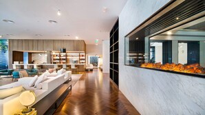 A modern hotel lobby with a wooden floor, a reception desk, a seating area with sofas, and a large window overlooking the city. - Le Méridien Abu Dhabi Resort (Abu Dhabi)