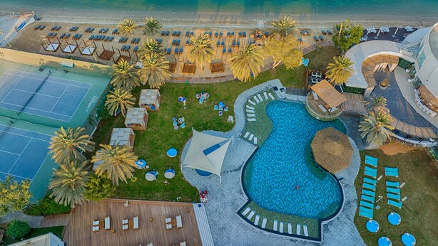 An aerial view of a resort with a pool, sun loungers, and a tennis court. - Le Méridien Abu Dhabi Resort (Abu Dhabi)