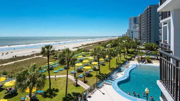 Um resort com piscina, praia e vista para o oceano.