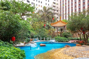 A swimming pool with a traditional pavilion, surrounded by lush greenery and a stone pathway. - China Hotel, Guangzhou (Guangzhou)