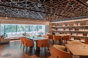 Una biblioteca moderna con un techo geométrico, ventanas amplias y diversas opciones de asientos.