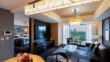 A modern hotel room with a city view, a dining area, and a cozy seating space.