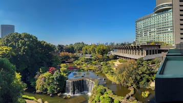 Un edificio moderno con fachada curva y jardín en la azotea.