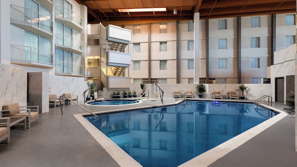 An indoor swimming pool with multiple levels of balconies, marble flooring, and seating areas.