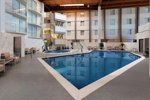 Una piscina techada, una piscina al aire libre de temporada, sombrillas