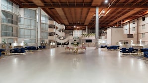 A spacious lobby with a high ceiling, multiple seating areas, and a central decorative table.