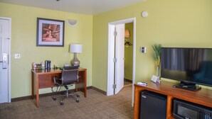 A hotel room with a desk, chair, television, microwave, and a door leading to a closet. - Quality Inn Merced Gateway to Yosemite (Merced)