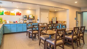 A restaurant with blue cabinets, wooden tables and chairs, and a coffee station. - Quality Inn Merced Gateway to Yosemite (Merced)