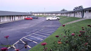A parking lot with a row of motel-style buildings. - Topeka Plaza Inn (Topeka)