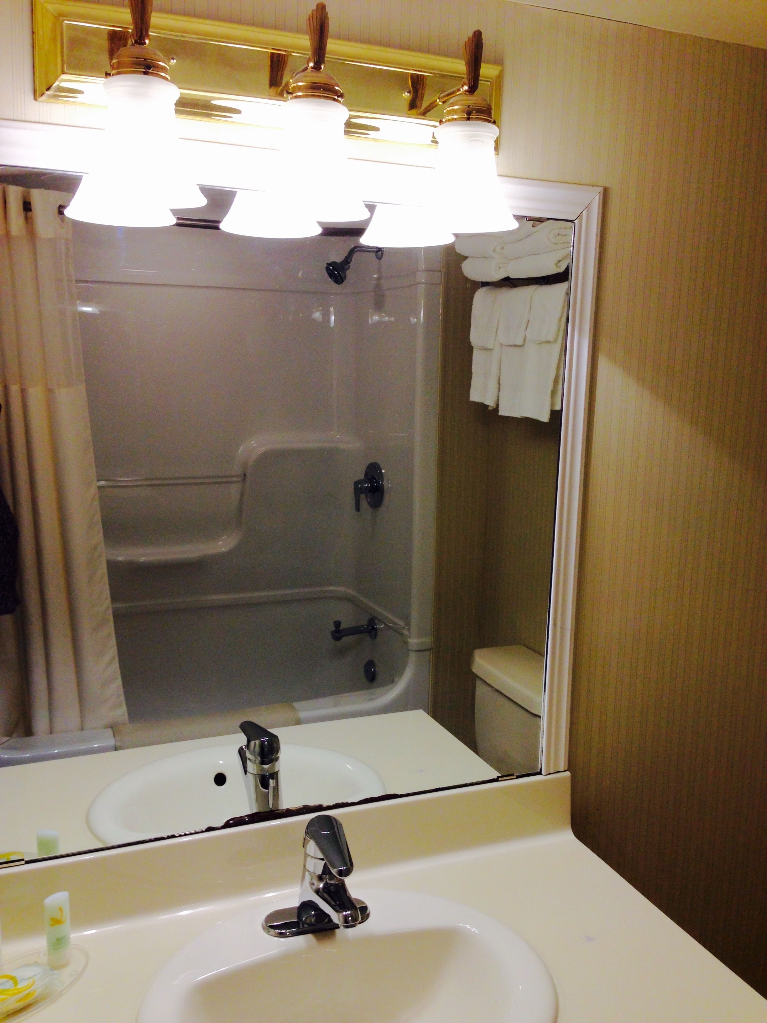 A bathroom with a white sink, a mirror, and a shower area.