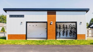 A modern building with two garage doors, one with a wooden panel and the other with bicycles mounted on the wall. - Quality Inn & Suites Garden of the Gulf (Summerside)