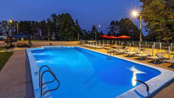 Una piscina al aire libre de temporada, sombrillas