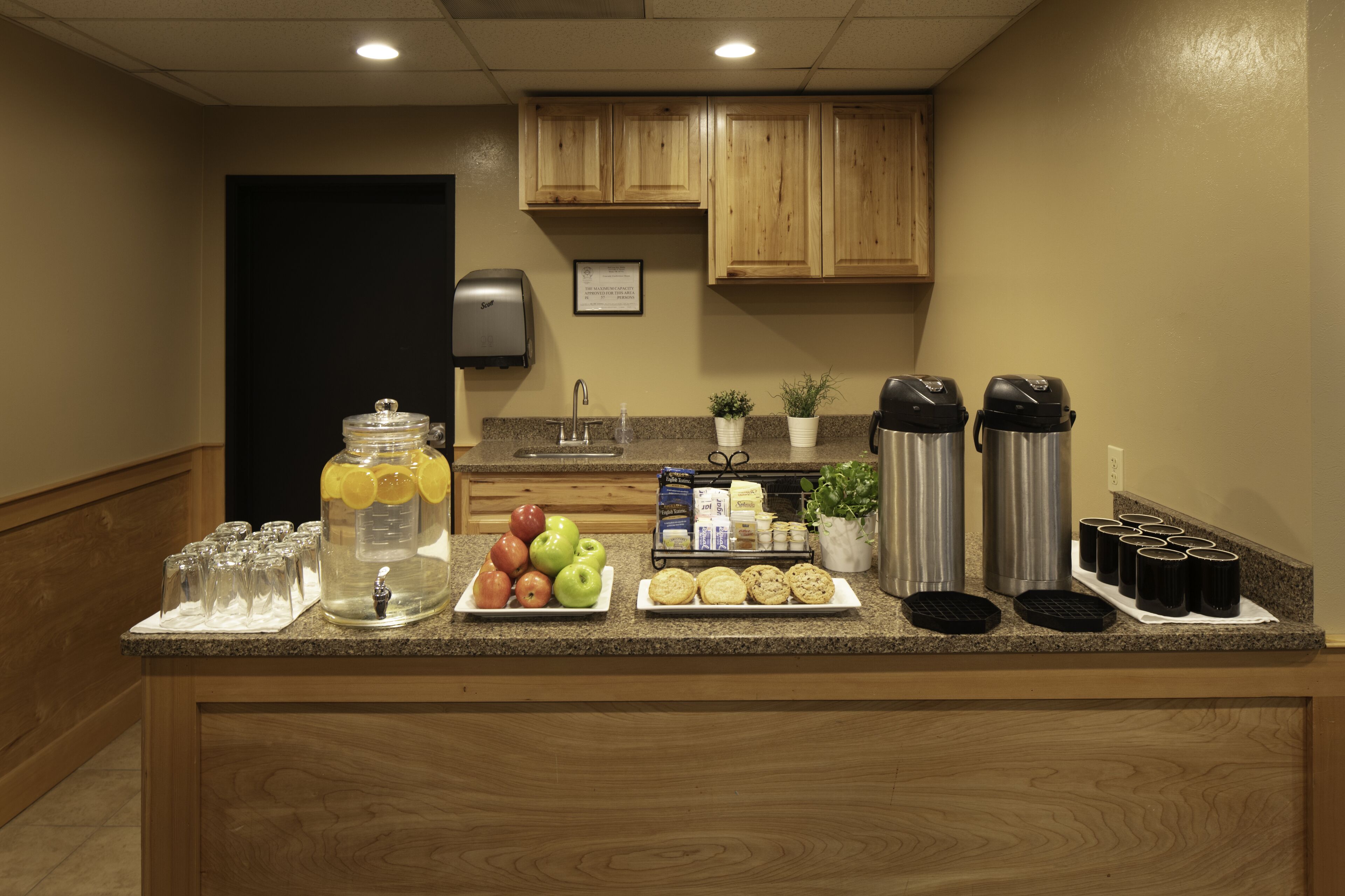 A kitchen counter with a fruit bowl, coffee makers, and a water dispenser.