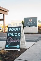 A sign for a food truck and a Waypoint Hotel entrance.