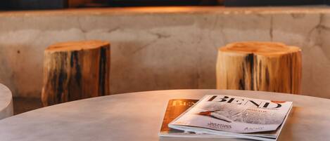 A magazine on a round table with a fireplace in the background.