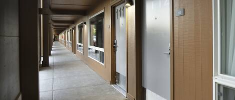 Un couloir avec des portes numérotées 111 et 112, qui donnent accès à des pièces.