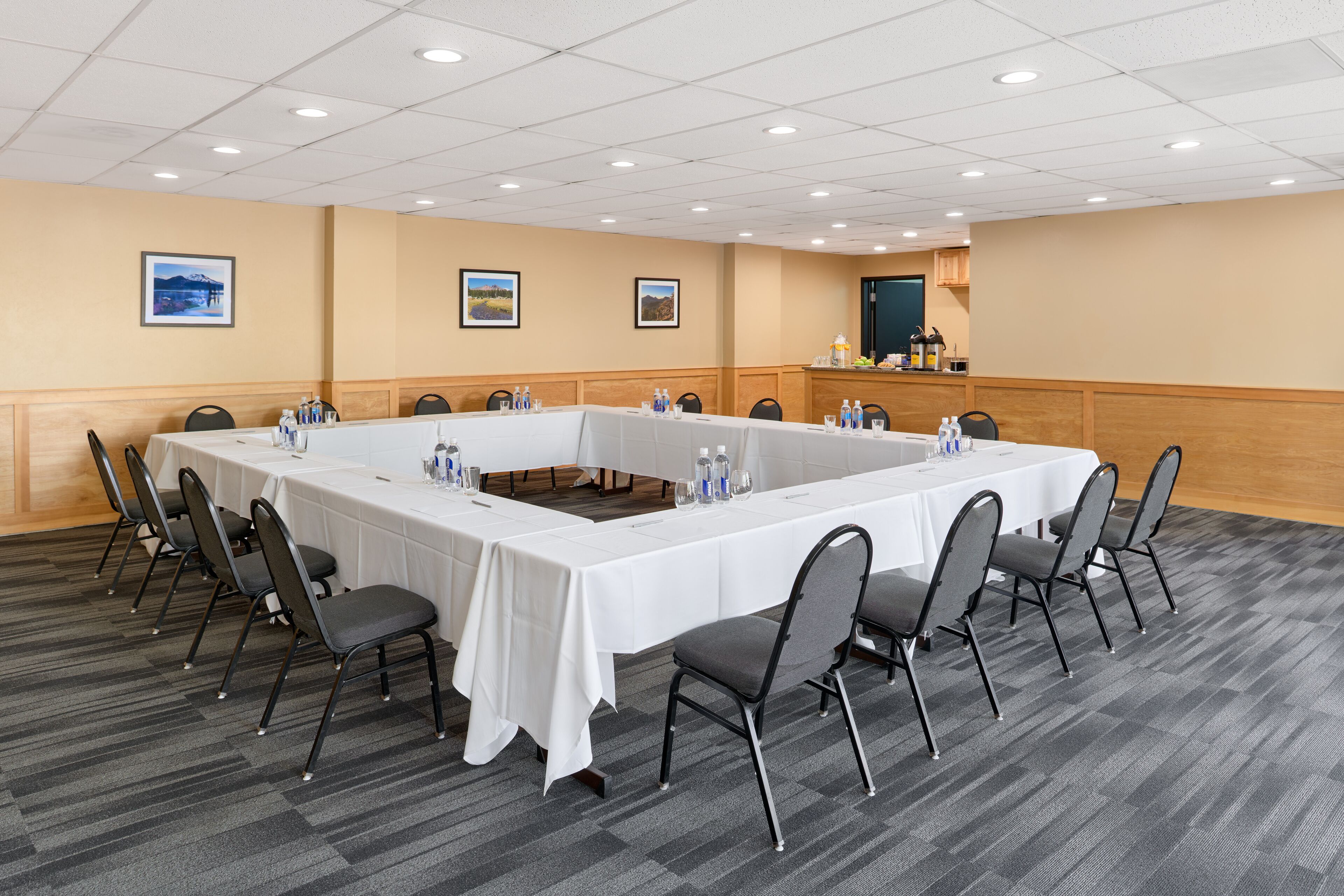 Une salle de conférence avec une longue table, des chaises et un pupitre.