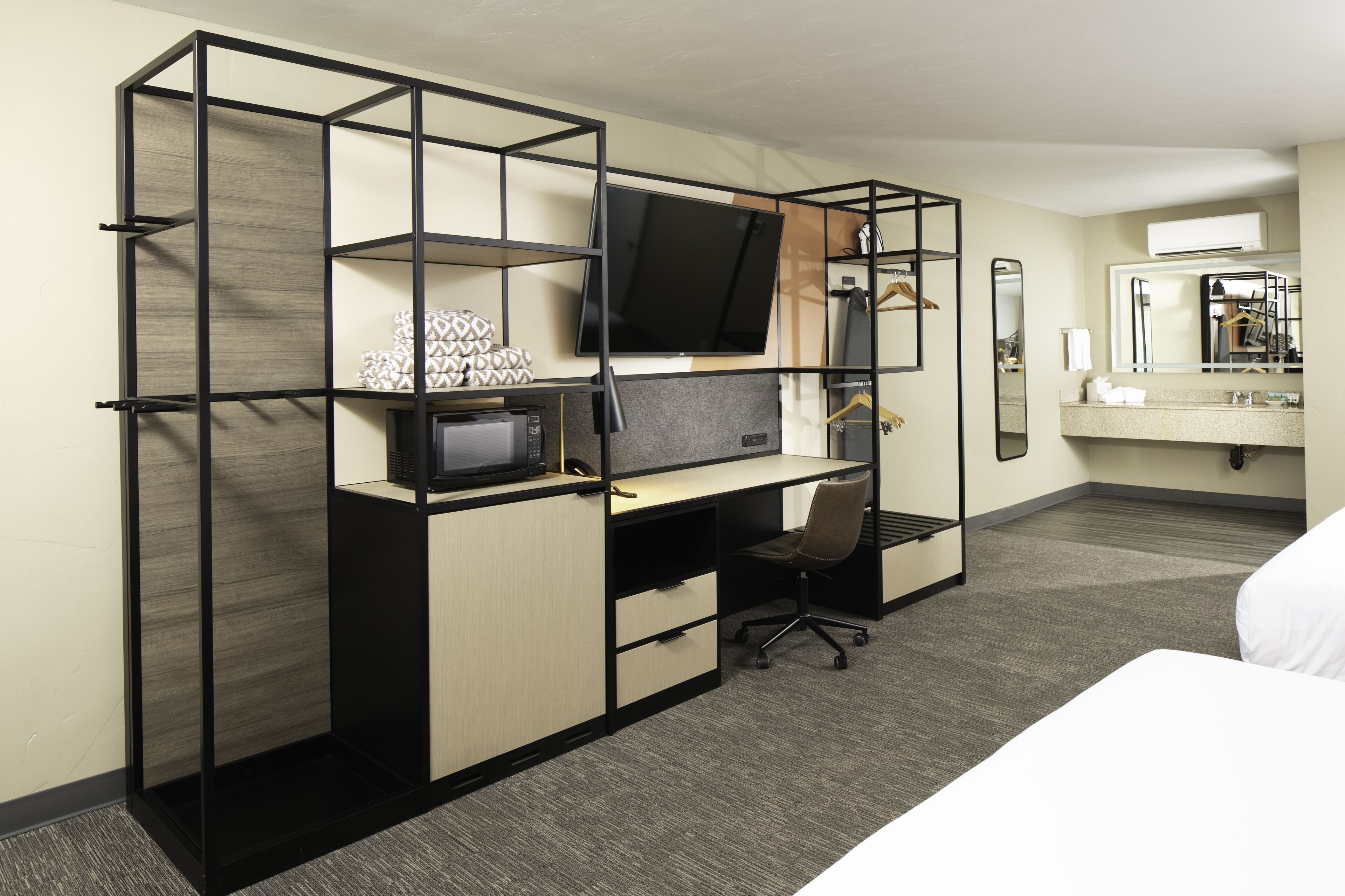 Une chambre d’hôtel équipée d’un bureau, d’une télévision et d’un lit.