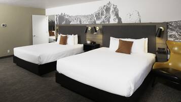 Habitación de hotel con dos camas, un mural grande en la pared y un diseño moderno.