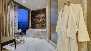 Un baño moderno con bañera, cabina de ducha de vidrio y un perchero para bata.