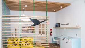 A modern office space with a wooden slatted partition, a blue desk, and a white chair. - ibis Styles Geraldton (Tarcoola Beach)